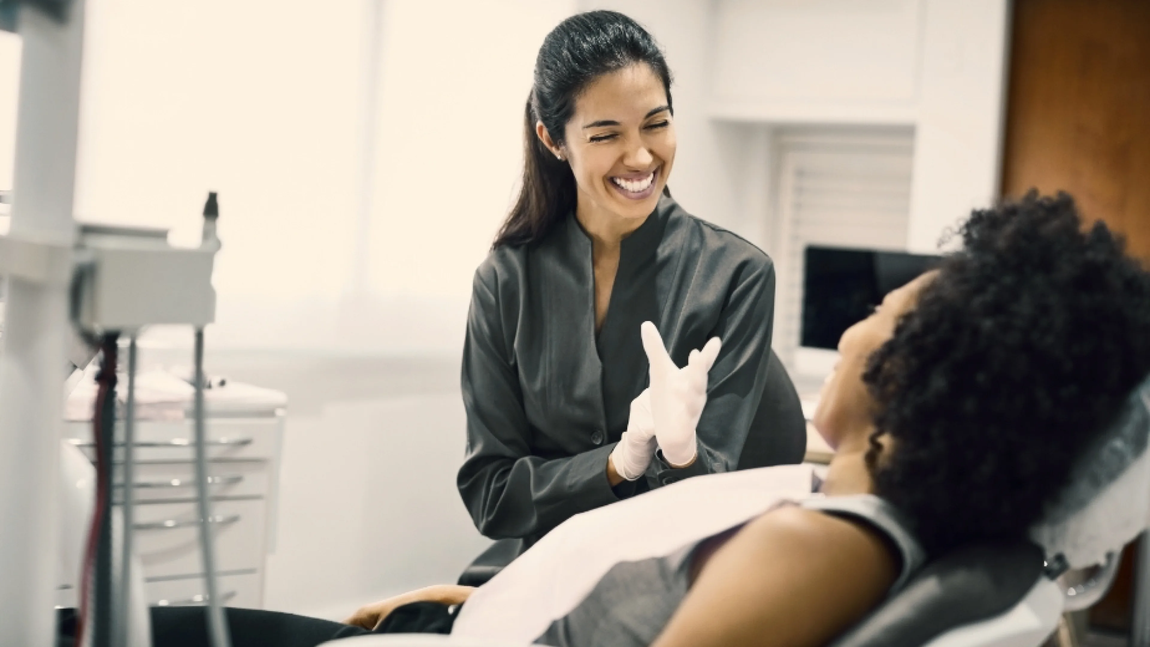 Dental assistant smiling at patient during explanation